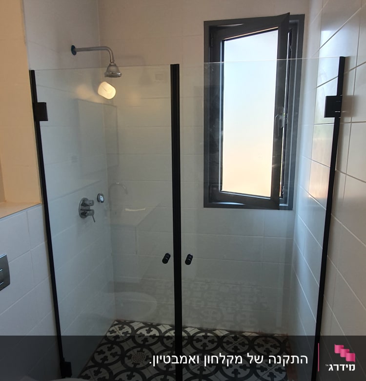 מקלחון זכוכית עם ראש מקלחת וקיר אריחים לבנים